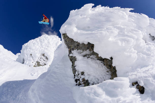 snowboarder jumping off a cliff. - ski jumping snowboarding snowboard jumping imagens e fotografias de stock