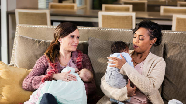 istock Two mothers and babies on sofa, nursing, crying 1198651709