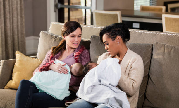 istock Two mothers and babies on sofa, nursing 1198651919