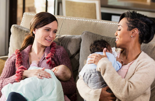 istock Two mothers and babies on sofa, nursing 1198651920