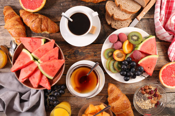 istock table with healthy and full breakfast- coffee cup, fruit and croissant 1198652020