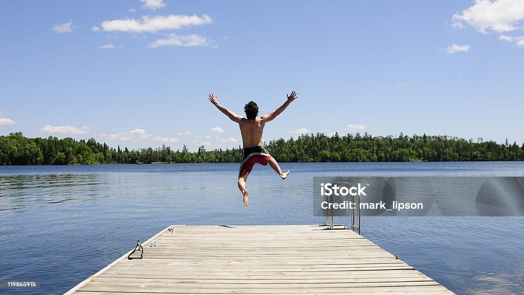 Jeune homme jogging sur dock sur belle journée d'été - Photo de Sauter libre de droits