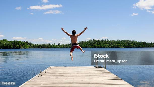 Photo libre de droit de Jeune Homme Jogging Sur Dock Sur Belle Journée Dété banque d'images et plus d'images libres de droit de Sauter