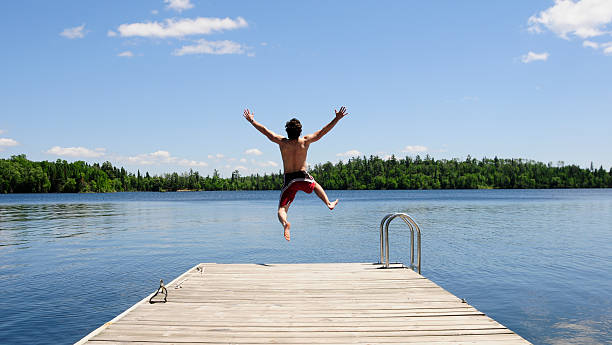 istock Young man running off dock on beautiful summer's day 119865915