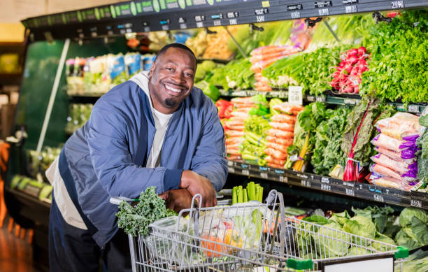 l'uomo afro-americano al supermercato produce corridoio - supermarket groceries shopping healthy lifestyle foto e immagini stock