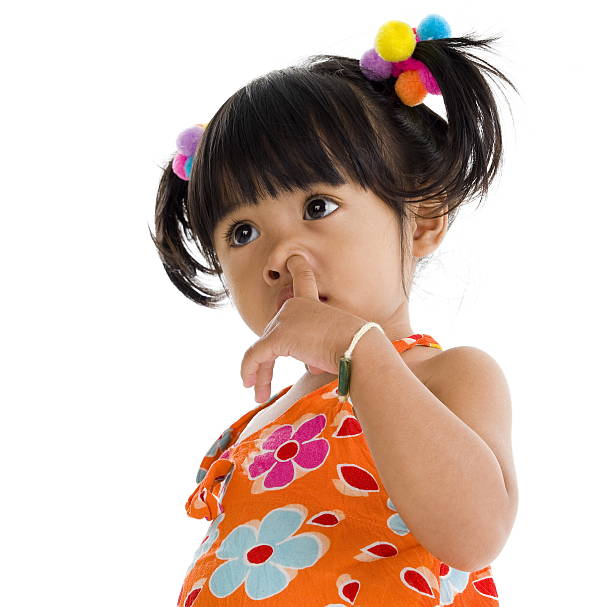 A young preschool girl placed her right palm on left chest (Malaysian way of greetings) as alternative to handshakes during partial lockdown in Malaysia.