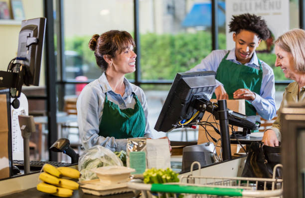 Customer and employees at supermarket checkout