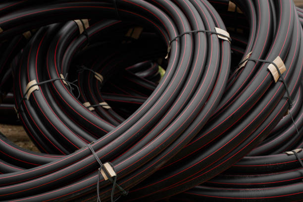 istock Black rubber or plastic pipes with a red lines as a construction material and equipment at building site. Using as a water pipe. 1198660452