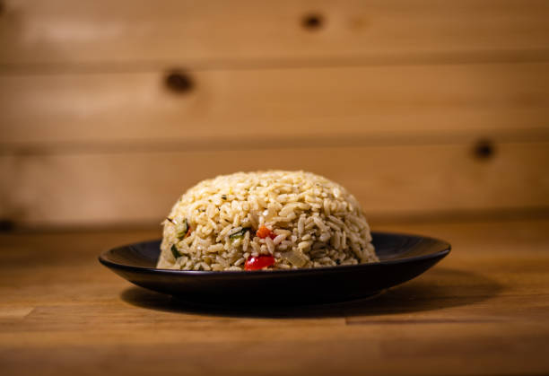 istock Appetizing healthy rice with vegetables in a bowl on a wooden background 1198660630