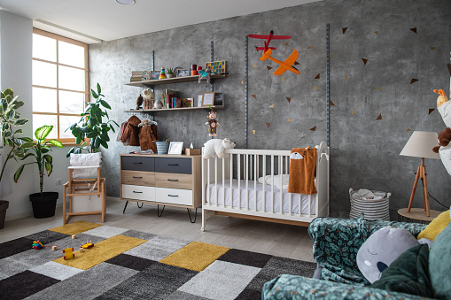 Empty children's playroom with crib, toy planes, plants, furniture