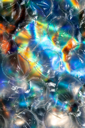 Close Up of Round Bubble Wrap on Top of Shiny Paper to Make an Abstract Background
