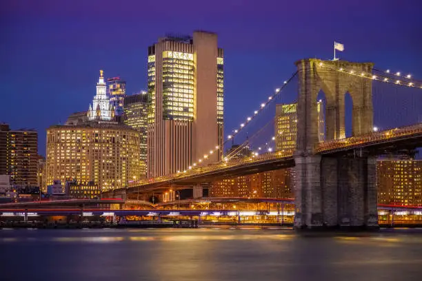 Photo of Brooklyn Bridge, Manhattan Municipal Building and East River at Sunset, New York, USA.