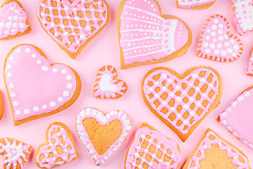 Handmade Glazed Decorated Heart Shaped Cookies on Pink Background. Concept of Happy Valentines Day. Top view