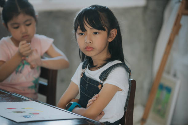 istock leave me alone; Thai baby girls having problems while studying in art class 1198679862