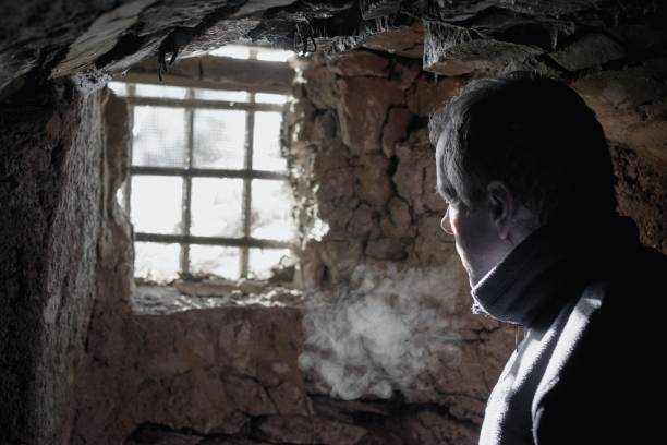 istock Man prisoner or captive in the dark underground cell 1198680269