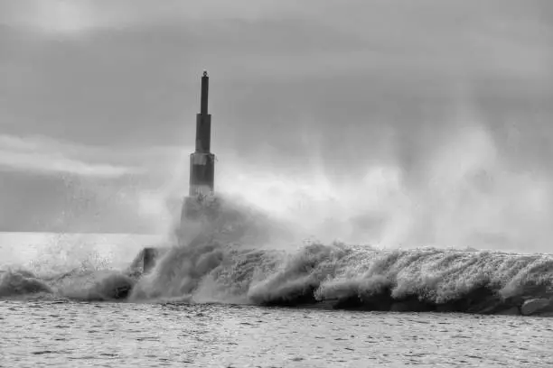 Photo of Giant waves breaking on the breakwater and the lighthouse
