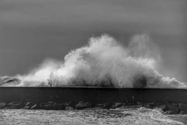Photo of Giant waves breaking on the breakwater and the lighthouse