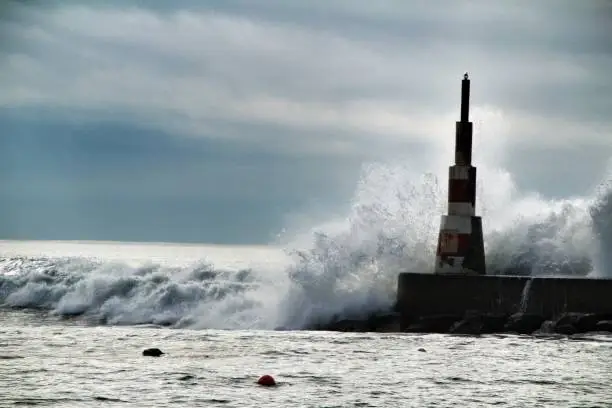 Photo of Giant waves breaking on the breakwater and the lighthouse