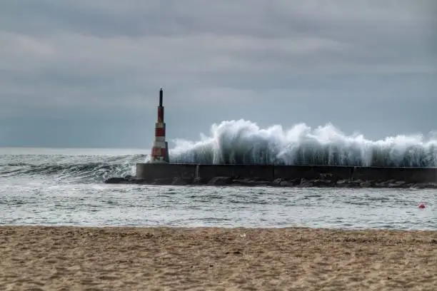 Photo of Giant waves breaking on the breakwater and the lighthouse