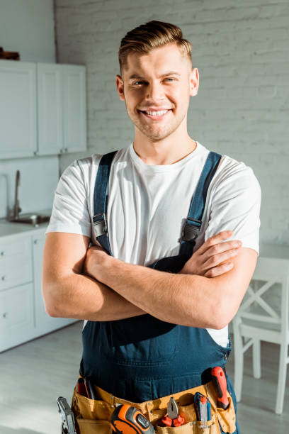 istock happy installer in overalls standing with crossed arms 1198683401