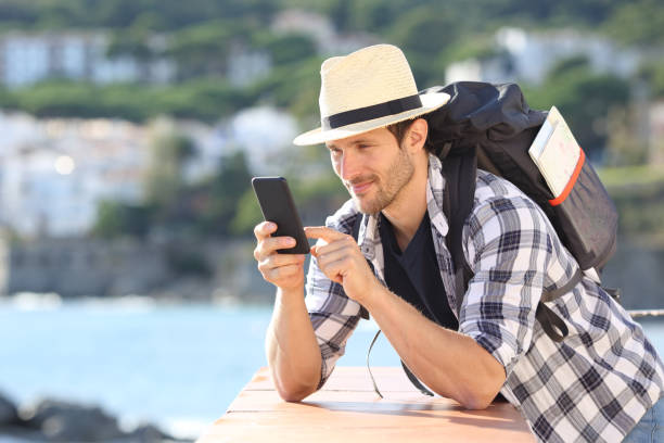 istock Serious tourist checking mobile phone in a coast town on vacation 1198686083