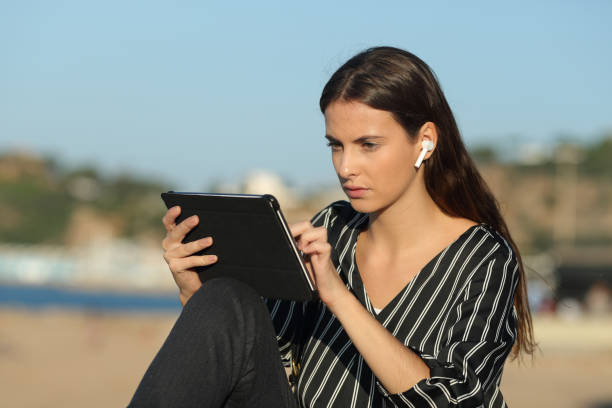 istock Serious woman e-learning with a tablet and earphones 1198686781