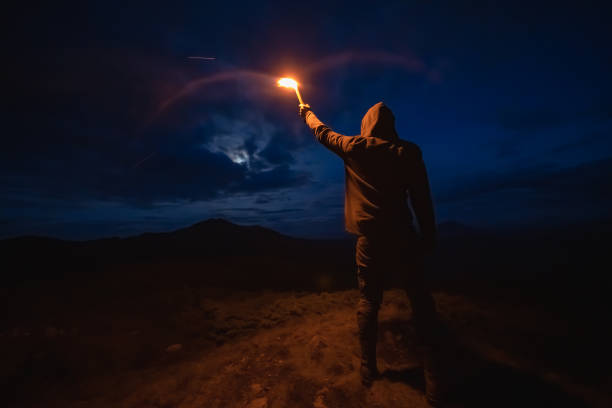 istock The male with a firework stick standing on the night mountain 1198689191