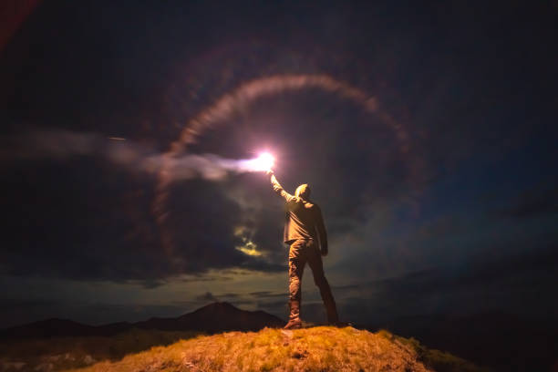istock The male with a bright firework stick standing on a mountain. evening night time 1198689215