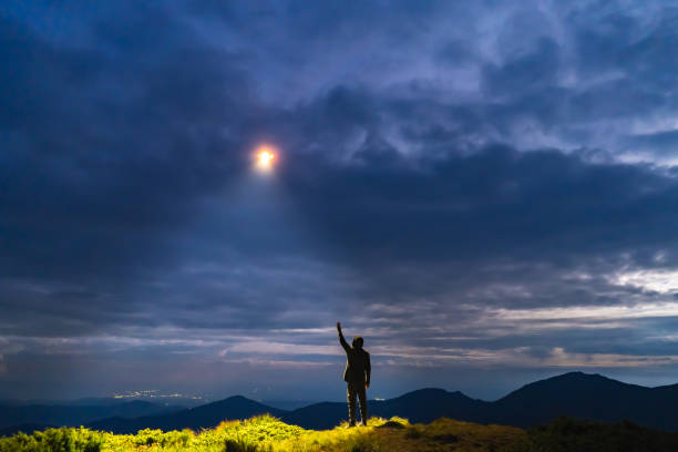 istock The UFO shines on a man standing on the mountain 1198689242