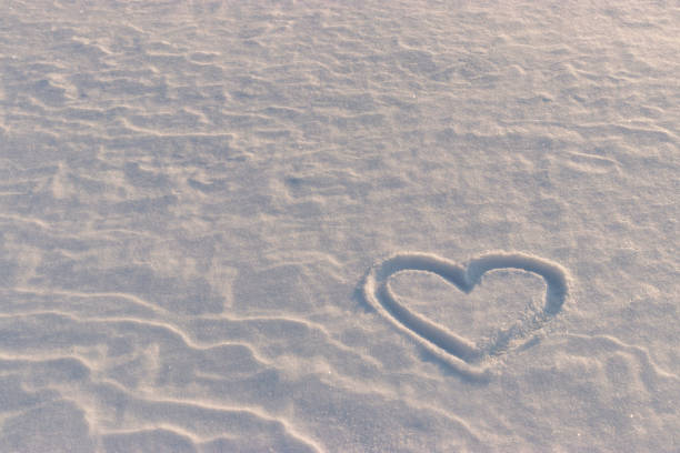 A heart is painted on blue snow on a bright sunny winter day. Background for an inscription.