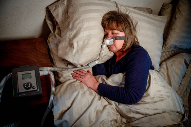 istock Middle Aged Woman in her Fifties Sleeping Peacefully in Her Bed Using a CPAP Machine to Provide Therapy for Sleep Apnea 1198690734