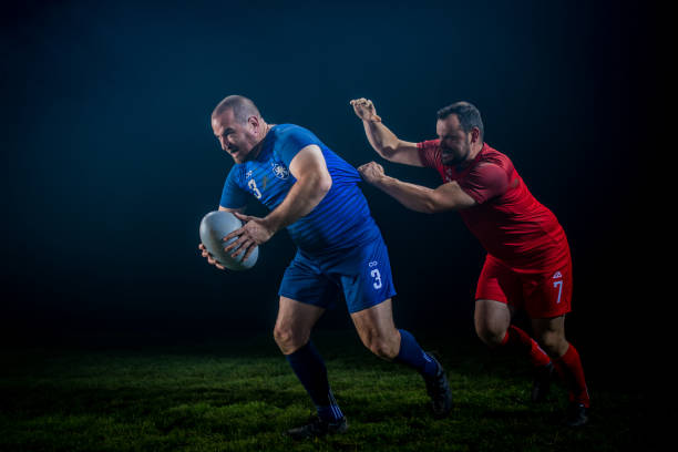 istock Determined rugby player running with the ball while getting tackled from behind 1198693489