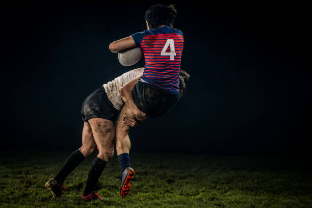istock Female rugby player getting tackled 1198693504