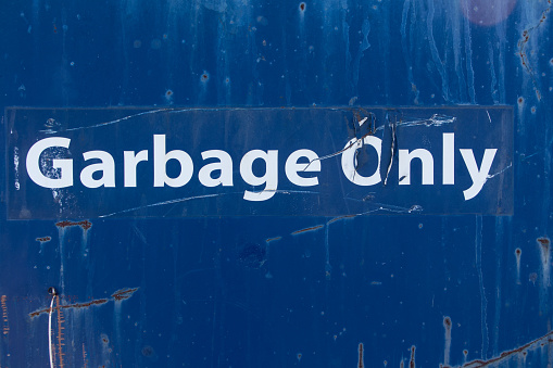 The side of a commercial garbage bin with the words 