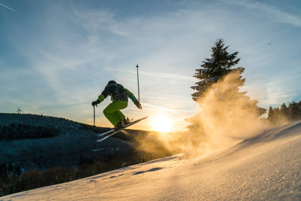 esquiador do downill que salta sobre o retrocesso natural na neve bonita do pó e em circunstâncias do por do sol - freeride - fotografias e filmes do acervo