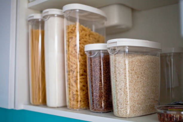 stocked kitchen pantry with food - pasta, buckwheat, rice and sugar . the organization and storage in kitchen of a case with grain in plastic containers. - storage containers imagens e fotografias de stock