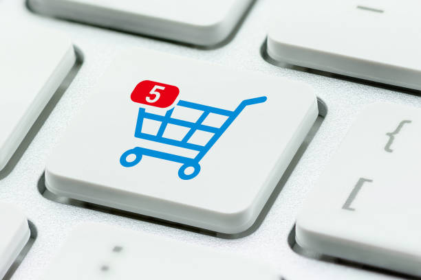 Online shopping / ecommerce and retail sale concept : Shopping cart with 5 items in a basket, a trolley symbol on a laptop keyboard, depicts customers order things from retailer sites using internet compras en línea / comercio electrónico y concepto de venta al por menor : carrito de compras con 5 artículos en una cesta, un símbolo de carro en un teclado portátil, representa a los clientes pedir cosas de sitios de minoristas utilizando internet