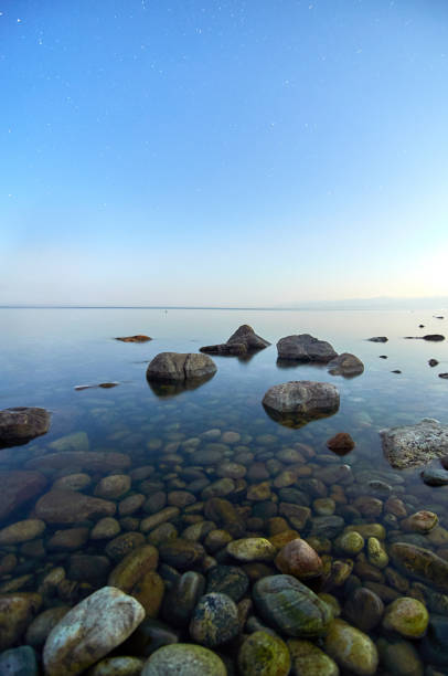 Lake Baikal in summer night. In the foreground is clear water and stones under water.