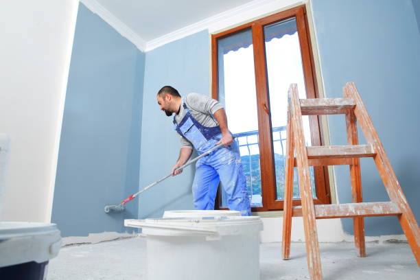 Painter man at work Painter man at work takes the color with paint roller from the bucket. With copy space house painter ladder paint men stock pictures, royalty-free photos & images