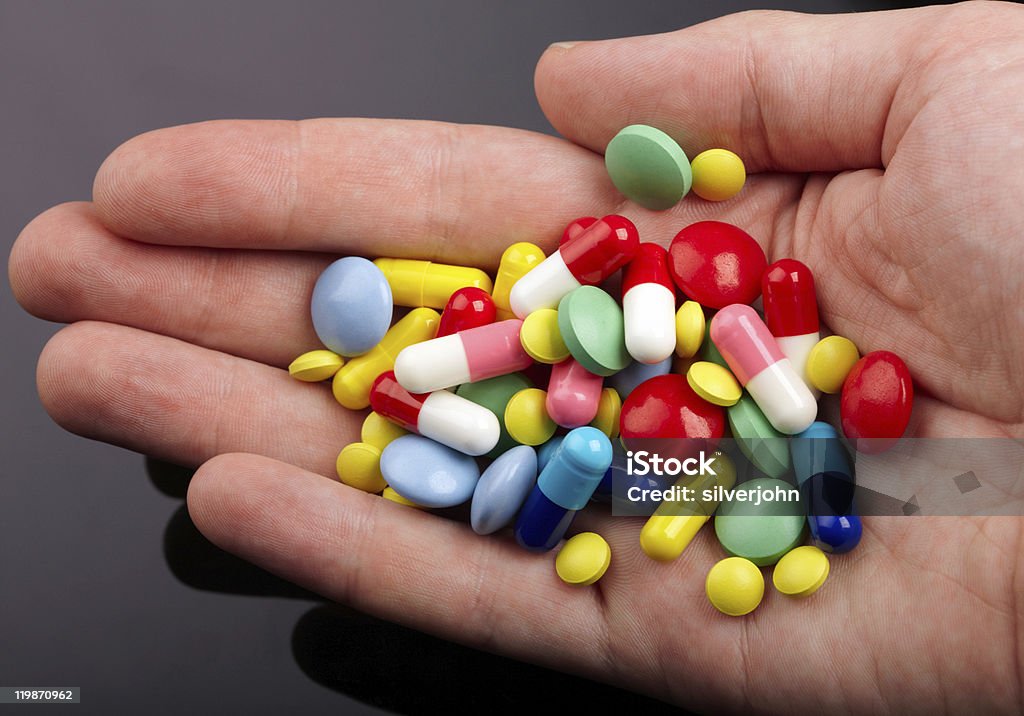 Mano con colorido pastillas - Foto de stock de Adulto libre de derechos