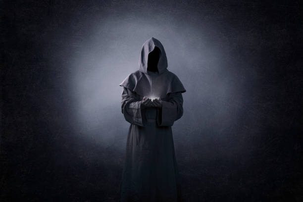 figura fantasmal con luz en las manos en la oscuridad - capucha fotografías e imágenes de stock