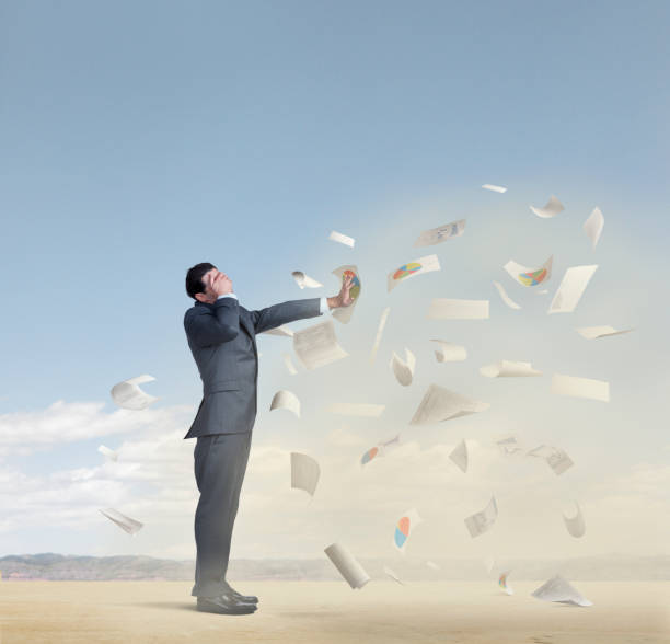 istock Businessman Protecting Himself From Sandstorm And Paperwork 1198712078