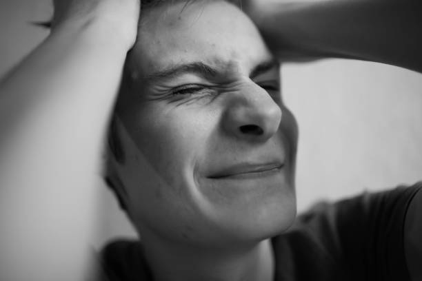 istock Teen guy squeezes his head and screams and grimaces 1198713051