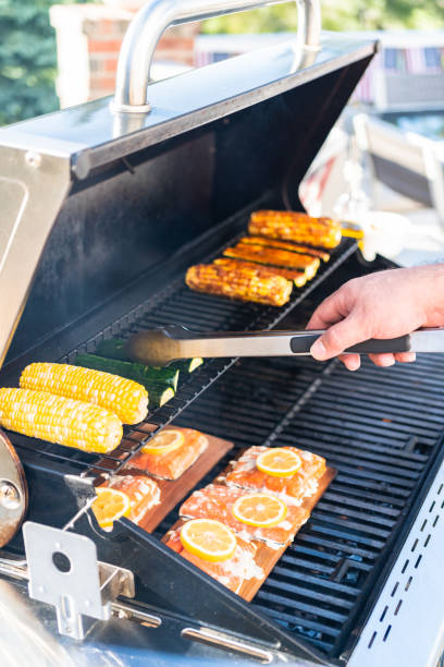 Grilling salmon on a gas burning grill on the backyard patio.