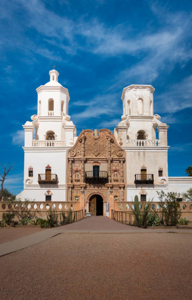 Frontal shot of Mission of San Xavier del Bac in Tucson with church tower and historic entrance Frontal shot of Mission of San Xavier del Bac in Tucson with church tower and historic entrance. Sunny daytime shot, blue sky with few clouds. No people visible. tucson christmas stock pictures, royalty-free photos & images