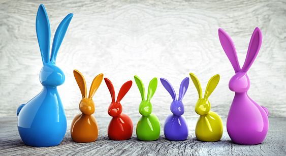 Colorful easter bunnies in a row in front of a wooden background
