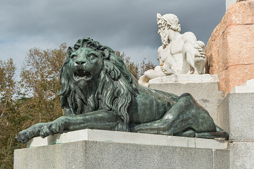 Madrid, Spain – Sept 26, 2019: Bronze statue of a lion from year 1843. Statue of king was produced by the Italian sculptor Pietro Tacca
