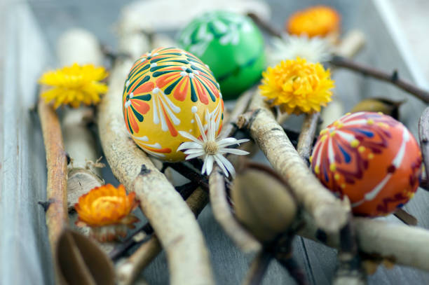 istock Homemade handmade painted Easter eggs on birch branches on grey wooden tray, traditional hnadcraft eggs 1198728485