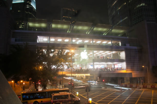 magasin apple brillant lumineux dans le centre de hong kong la nuit. il y a beaucoup de gens à l'intérieur du magasin. - store application software iphone mobile phone photos et images de collection