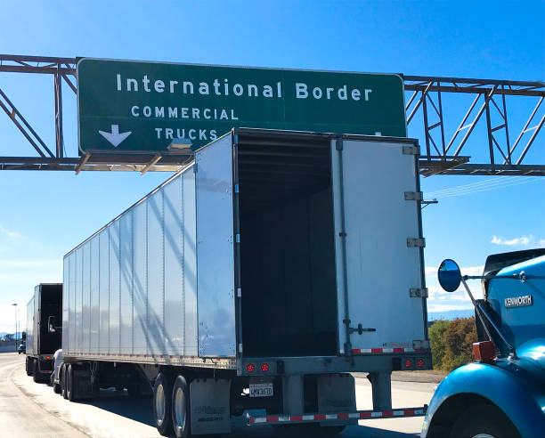Calexico, CA: Trucks awaiting inspection at the US-Mexico border crossing  at Calexico in southern California; one truck has its back door open.